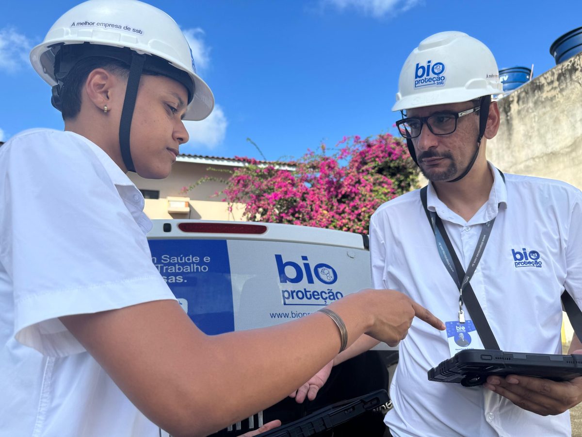 Dois técnicos da Bioproteção com capacete e tablet durante visita técnica de segurança do trabalho