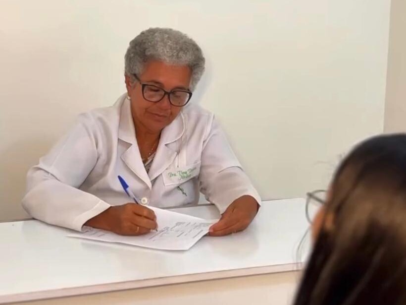 Médica do trabalho da Bioproteção preenchendo o ASO durante a consulta ocupacional